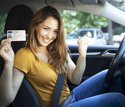 Young woman excited holding up drivers licence